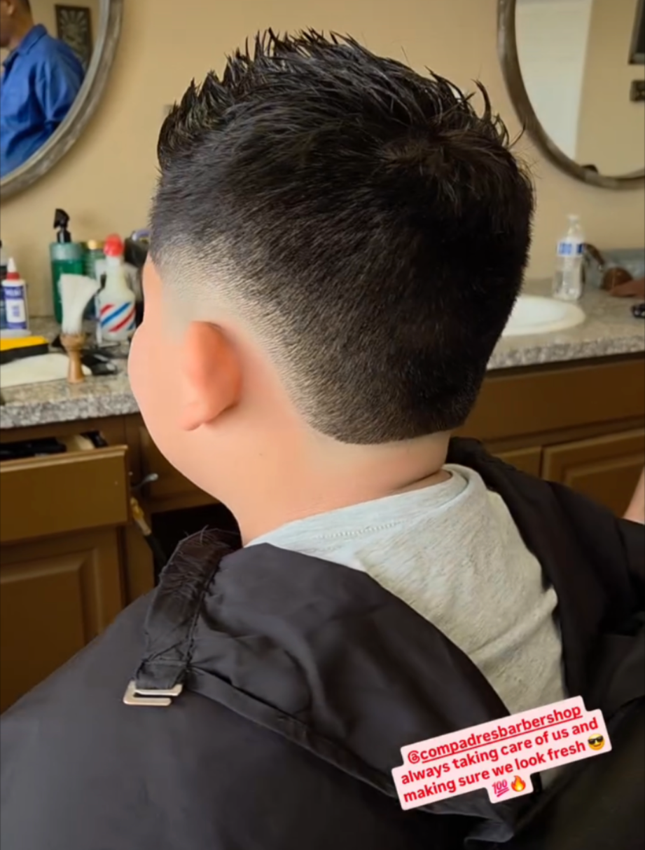 Spiky textured top with a clean mid fade by Martin at Compadres Barbershop